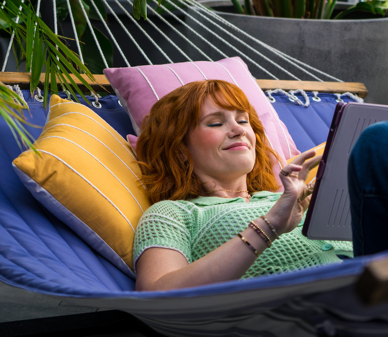 A female laying on a hammock with her tablet