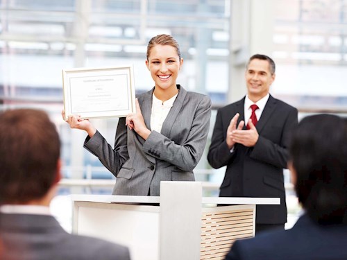 A female is showing her CFP® Certification to a group of people